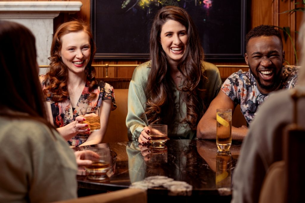 a group of people sitting around a table with drinks